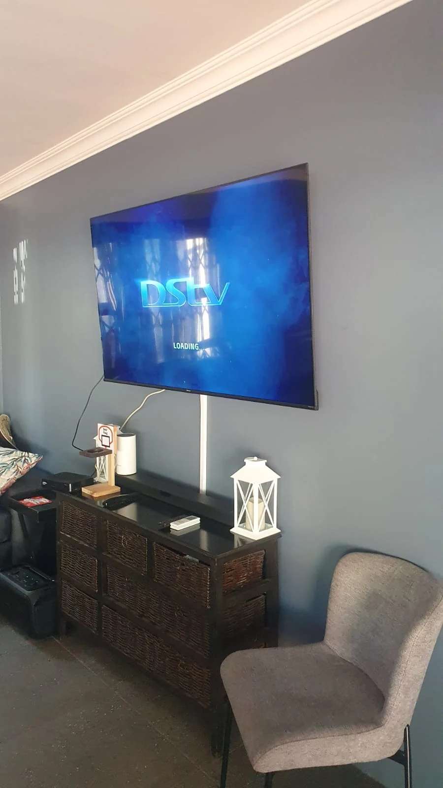 Wall-mounted television displaying a DStv loading screen