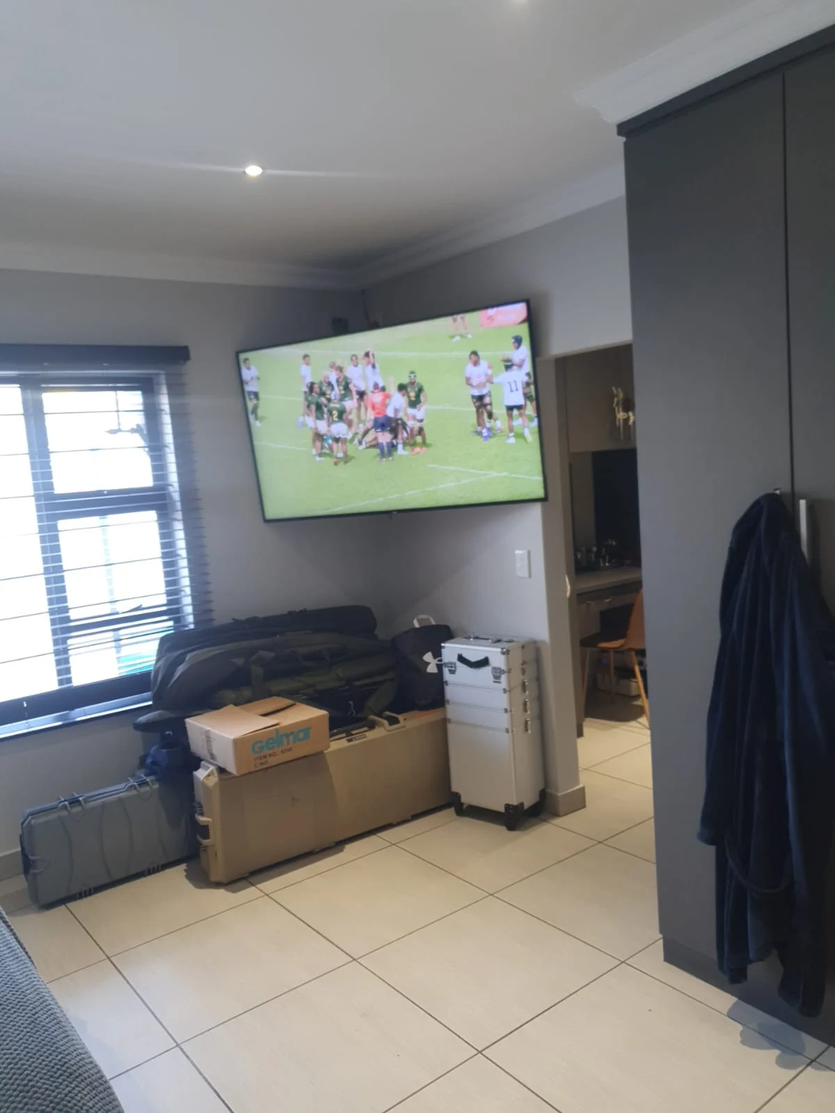 Wall-mounted television showing a rugby match